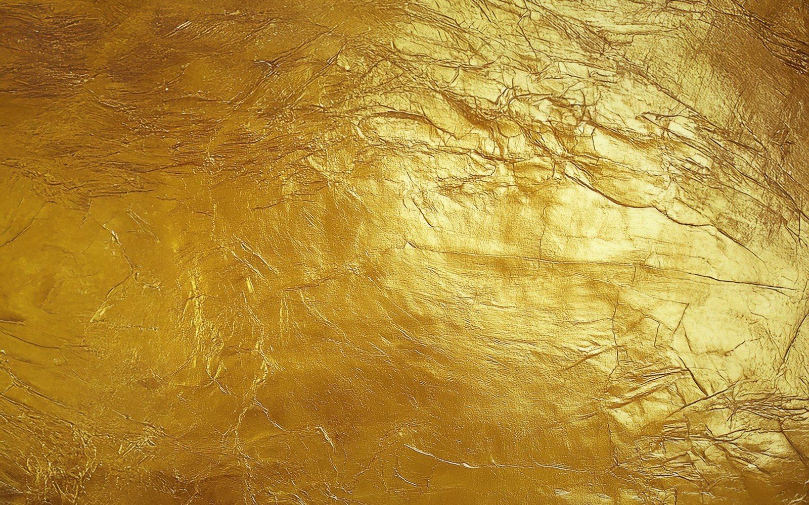 Gold leaf being burnished on a panel with an agate tool
