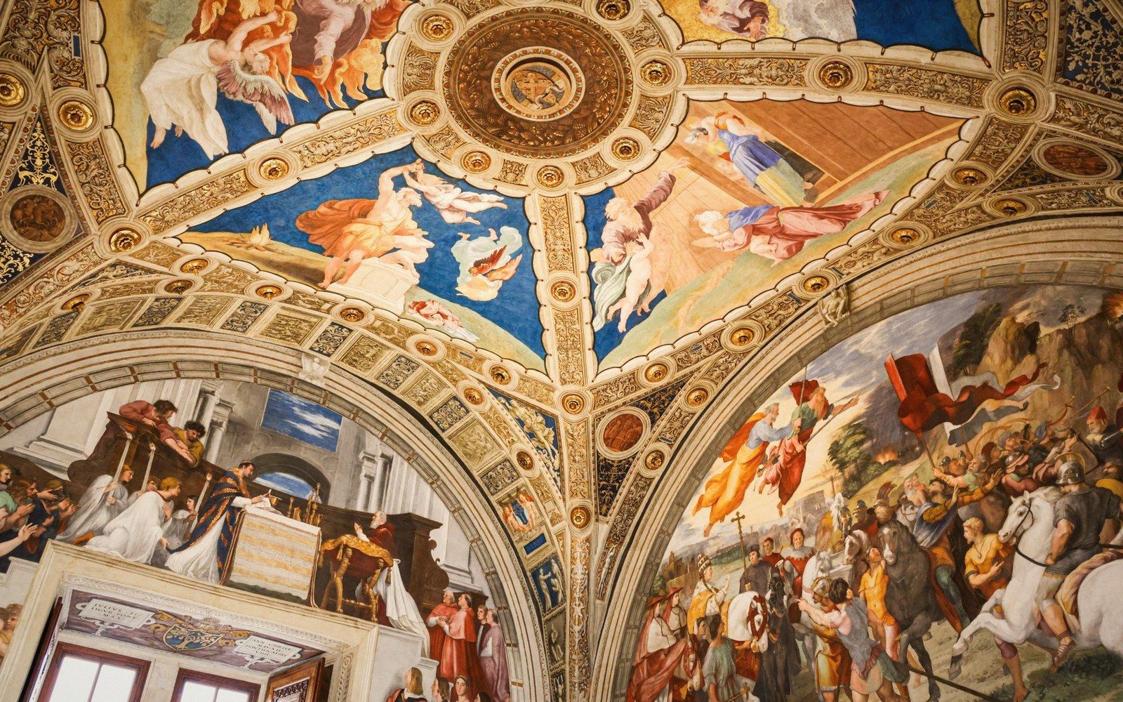 Ornate frescoed ceiling and arched walls depicting biblical scenes in gold-framed panels